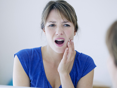 The image shows a woman with her hand on her chin, looking surprised or concerned, while another woman nearby appears to be brushing her teeth or holding her mouth.